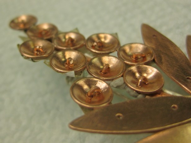 nail head rivets through back curved over